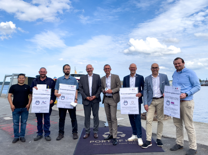 Schleswig-Holsteins Digitalisierungsminister Dirk Schrödter (Mitte) hat die Zuwendungsbescheide des Landes im Hafen von Kiel persönlich an die Projektpartner übergeben. Mit dabei waren Daniel Höche und Christian Feiler vom Hereon (Mitte links). Foto: Port of Kiel